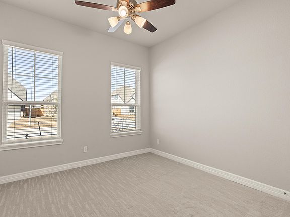 The secondary bedroom features plush carpet, large windows and access to a Jack and Jill bath.