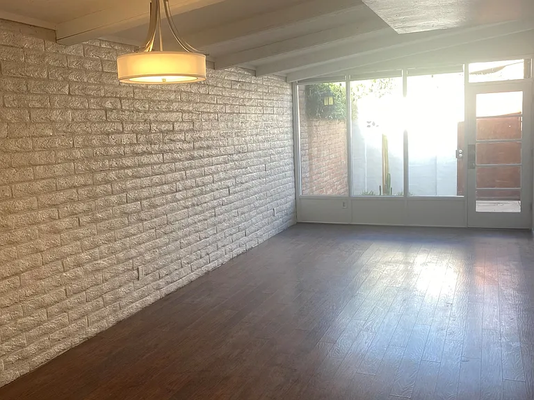 Spacious natural light living and dining area with large window to private patio.