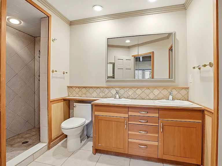 Enjoy the convenience of a private 3/4 ensuite bath featuring tile finishes and easy access to the primary suite's indoor and outdoor living spaces.