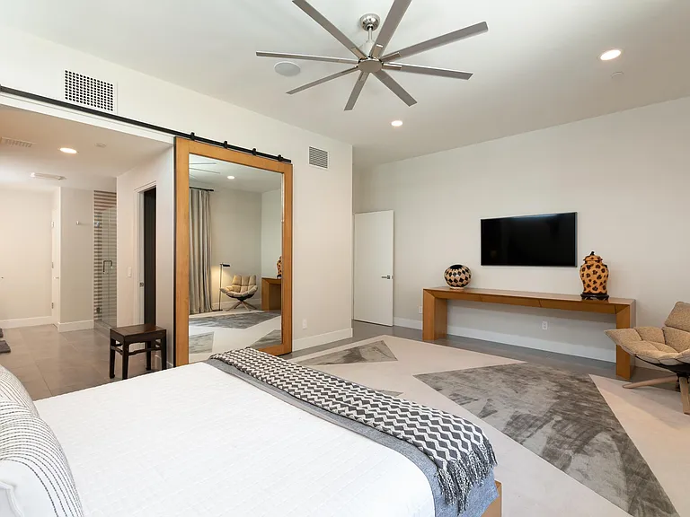The Mountain Bedroom with art television and view to bathroom and walk-in closet.