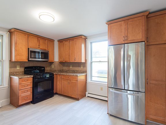 Kitchen featuring new flooring, full fridge/ freezer, oven/ stove, microwave and dishwasher.