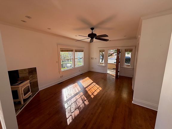 Living Room _ Bright and open living space with large windows, hardwood floors, and a cozy fireplace.