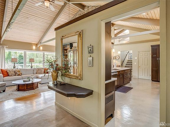 Soaring Beamed Ceilings, Expansive Windows welcome you! Hardwoods and Semco concrete overlay flooring grace this thoroughly remodeled home.