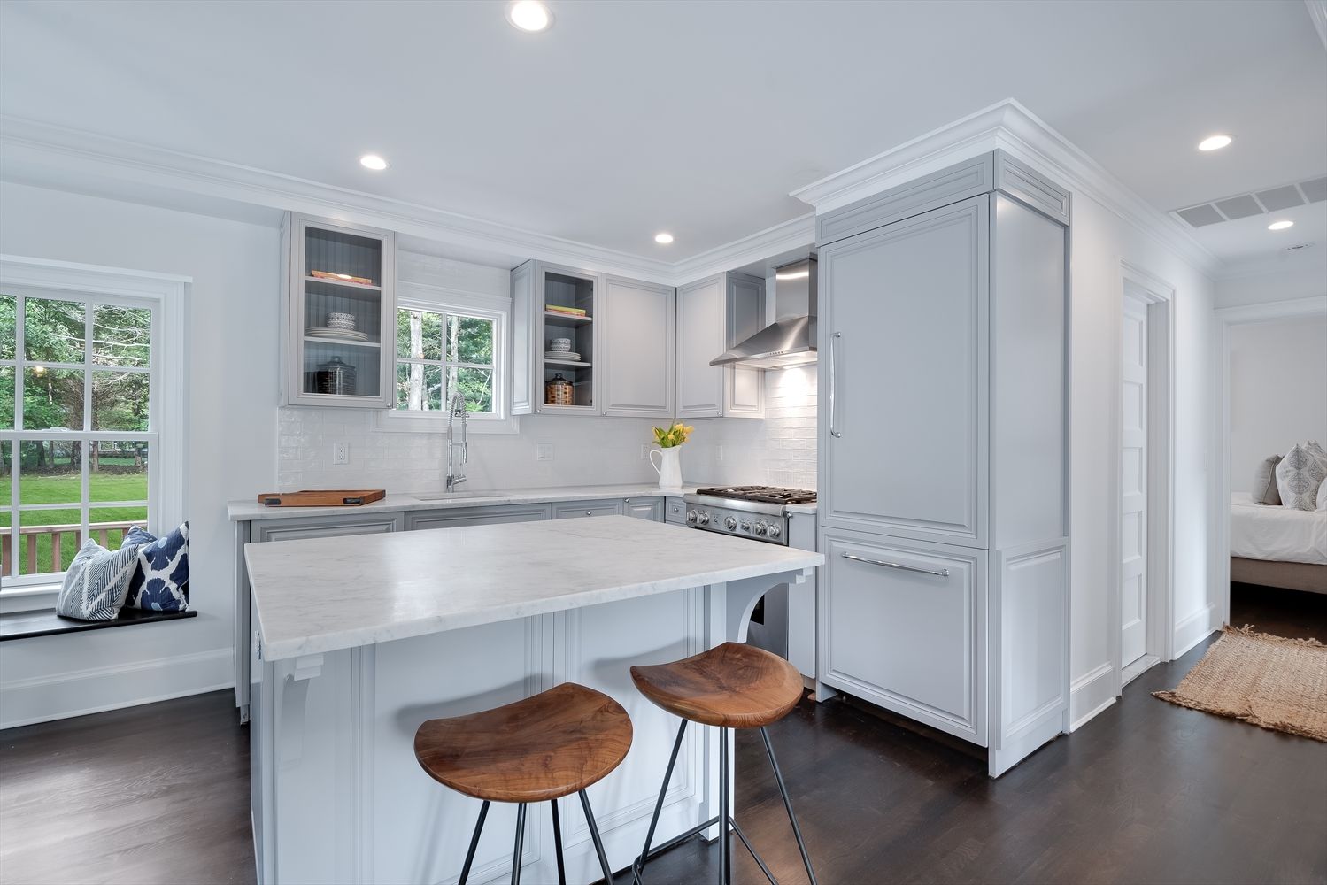 Open layout kitchen with carrera marble, custom cabinets, and Thermador appliances