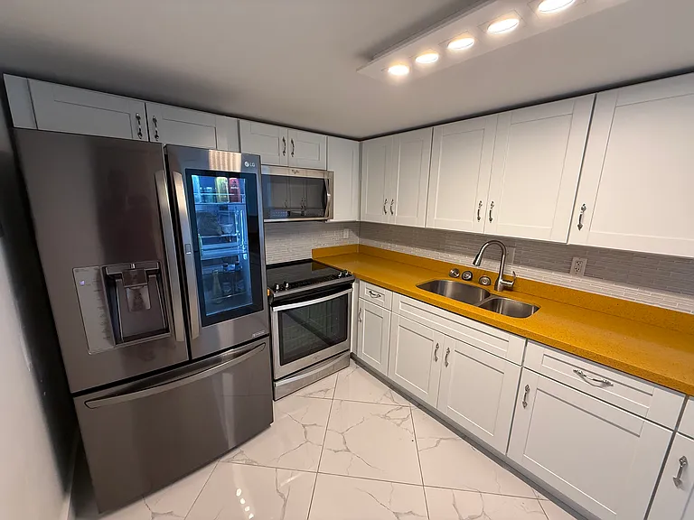 Open concept KITCHEN with limited edition custom quartz countertops, dimmable designer lighting & like-new LG & Whirlpool appliances