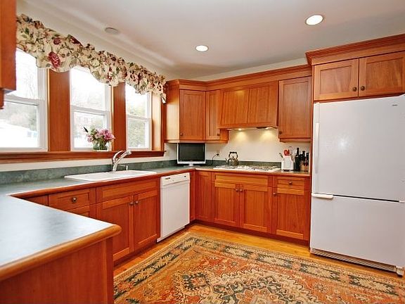 The updated kitchen features cherry cabinets and an eat-in area.