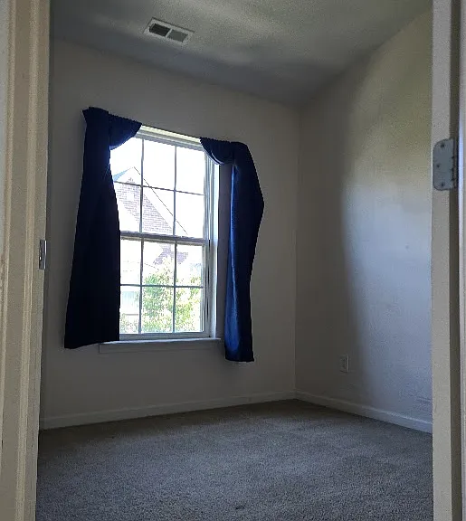 The guest room features a large window that fills the space with natural light, creating a bright and inviting atmosphere.