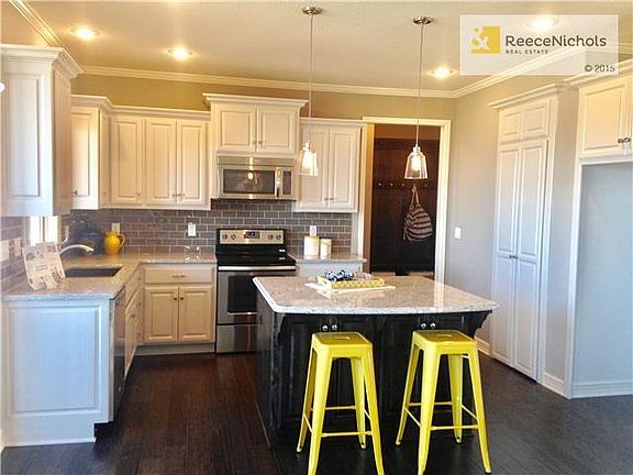 Fresh white cabinets with granite island dark stain contrast.