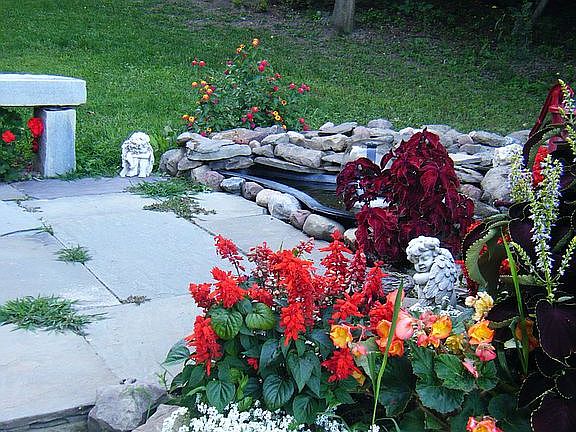 Slate patio with stone bench, fish ponds, and fountians