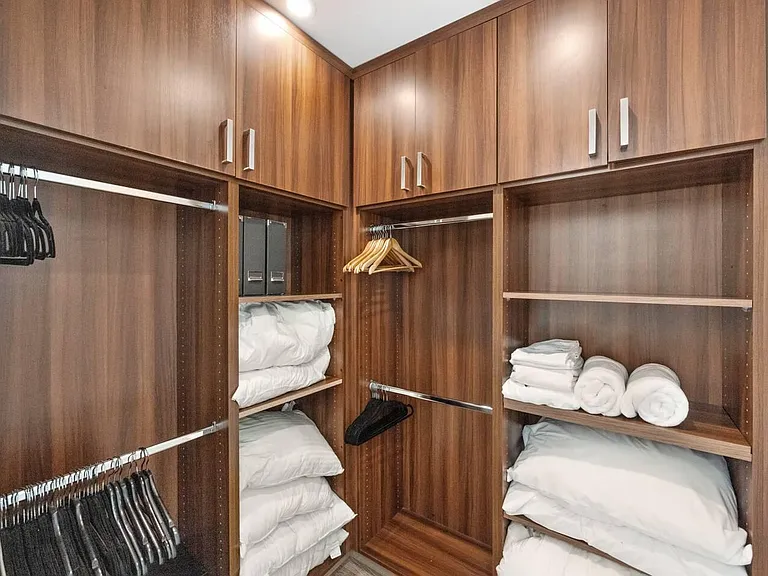 Organize your wardrobe in style in our expansive walk-in closet, offering ample space and luxurious detailing.