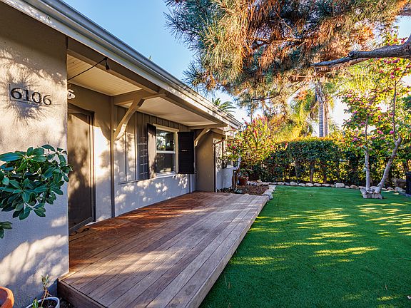 Front yard with shaded deck under mature trees
