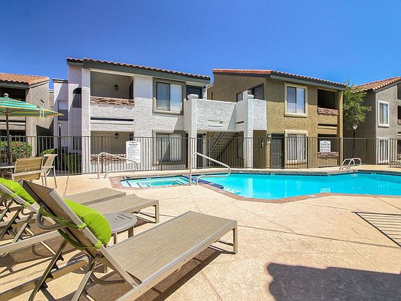 Courtyard pool and spa with long lounge chairs and umbrella-shaded picnic area.