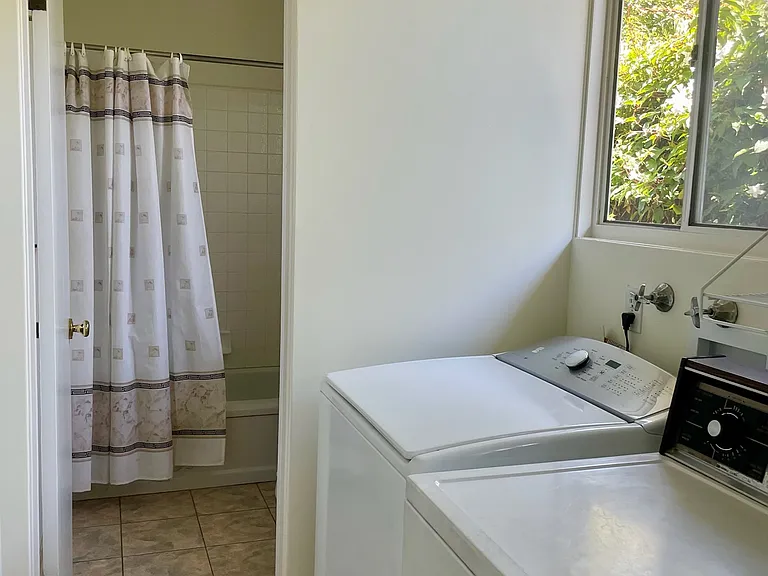 Washer and the dryer in the foreground with the 2nd bathroom in the background