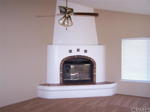 Adobe look to the fireplace in open floor plan to kitchen