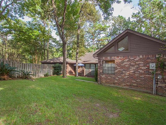 A large fenced yard offers a grassy space to enjoy the woode