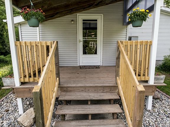 As you approach the entry door you are met by a paved sidewalk ending at a fully cover porch and surrounded by flower beds cloaked with drainage stone.  
