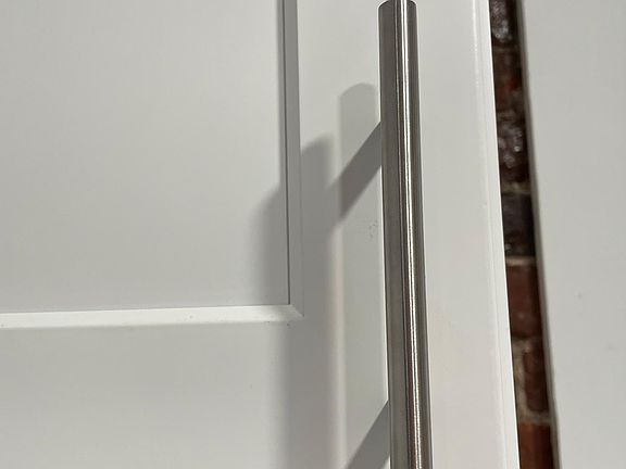 Stainless steel handles on Shaker style cabinets.