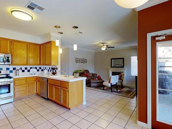 The kitchen and dining area open to the back yard and covered patio.