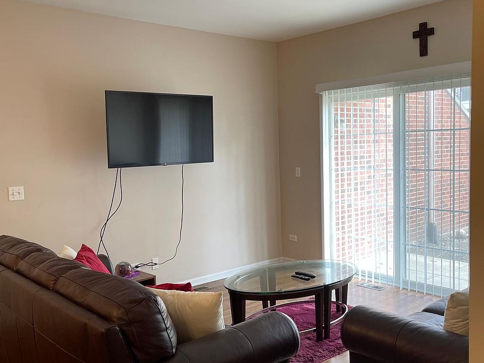 living room furnished with set of two sofas, coffee table and mounted tv