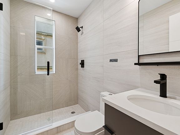 Full bath, seamless glass show door, modern finishes, floor to ceiling tile