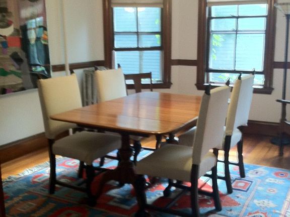 Dining room w bay windows onto urban garden