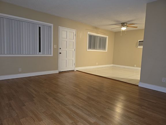 Living room has hardwood flooring and dining area has ceramic tile