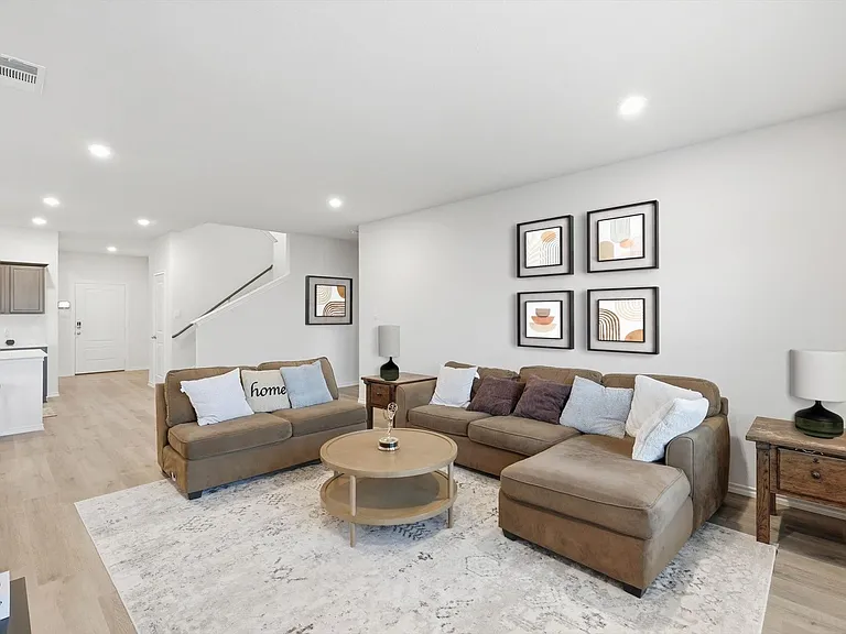 Living area with light wood-type flooring and recessed lighting