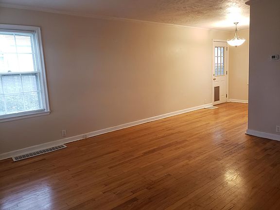 Large living room that opens into the dining room. Notice the doggy door that goes out to the screened in porch and back yard