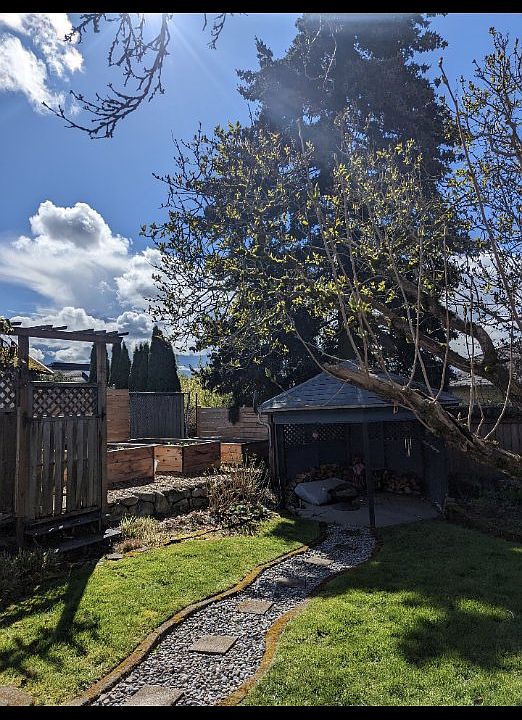 Front door of apartment opens to large shared backyard with shared raised garden beds