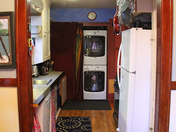Looking into the kitchen from the dining room, you'll find all the essentials_including a built-in dishwasher, full-size fridge, gas stove and oven, plus a stacked Maytag washer and dryer_making everyday living easy and efficient.
