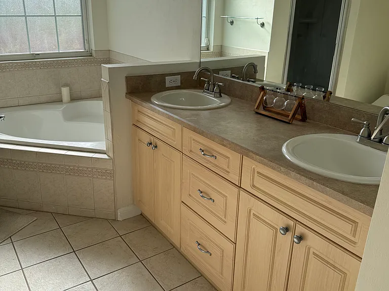 Master bathroom has side by side vanities, additional linen closet for stage, soaking tub, and separate walk-in shower.