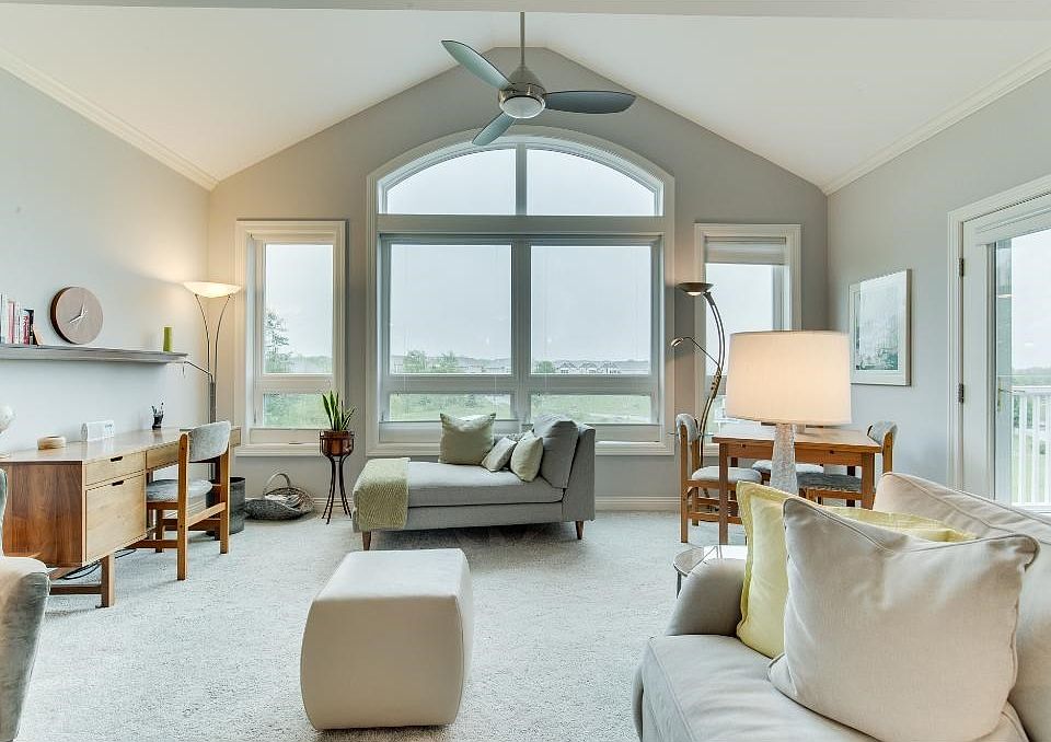 Living Room with vaulted ceilings, ceiling fan, electric fire place and transom window for added natural light.