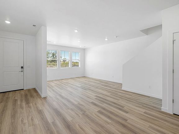 Light and bright family room with LVP flooring throughout. View of greenery outside of both windows (not looking at any other homes).