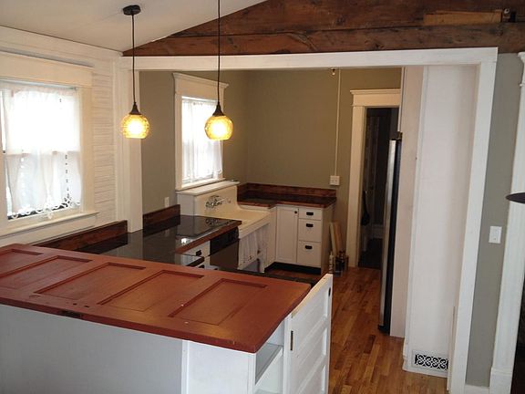 Kitchen: Bar from antique door, bead board, and exposed bric
