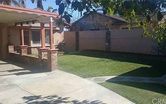 Backyard view towards house. Can see bay window and enjoy the artificial turf for low maintenance.