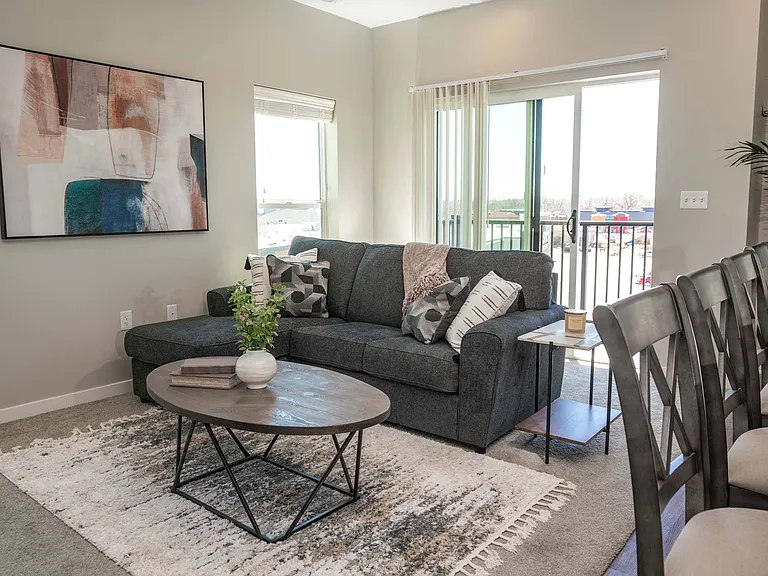 Couch and balcony exit in a unit at Heartland Flats Alliance.