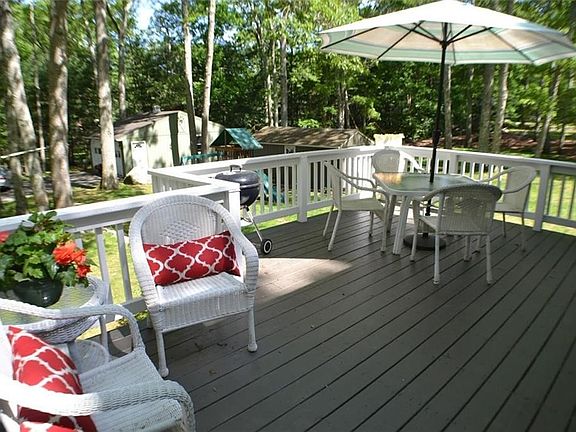 Stunning deck freshly painted with PPG custom paint to match the house.  View of the spacious yard with a view of all outer buildings.