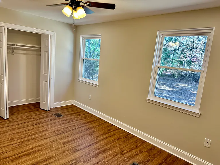 Oversized sunlit bedroom with expansive walk-in closets_designed for comfort, natural light, and exceptional storage space.