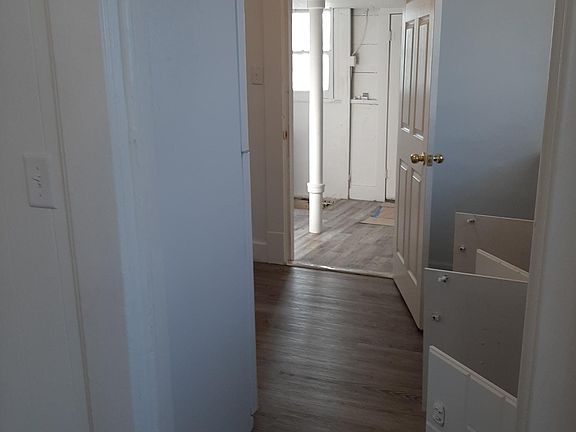 View of kitchen from dining room, looking through to utility room, which exits through back door with storm door to backyard.