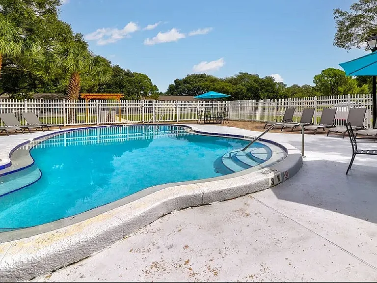 Inviting poolside oasis with crystal-clear waters, surrounded by comfortable lounge chairs and vibrant umbrellas, perfect for relaxation and leisure.
