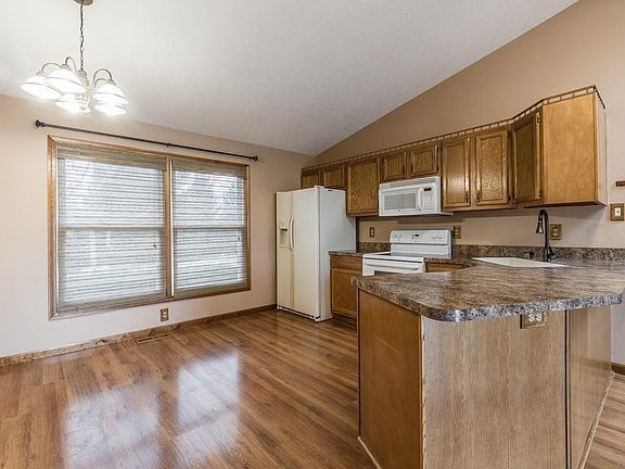Eat in kitchen with wood cabinets, a pantry, and the spacious feeling of an open floor plan.