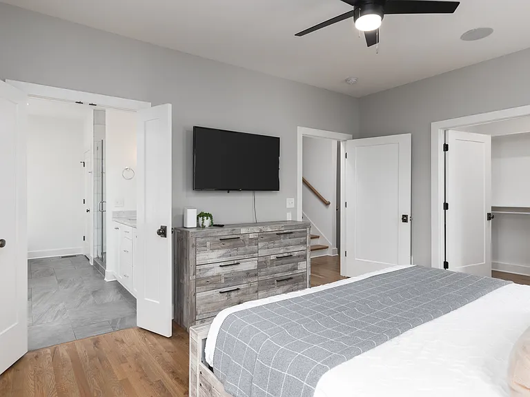 Primary bedroom on the 2nd floor with a king bed, Smart TV, ensuite bath, and room darkening shades. Includes a large walk-in closet. Tastefully decorated with high-end modern furnishings.
