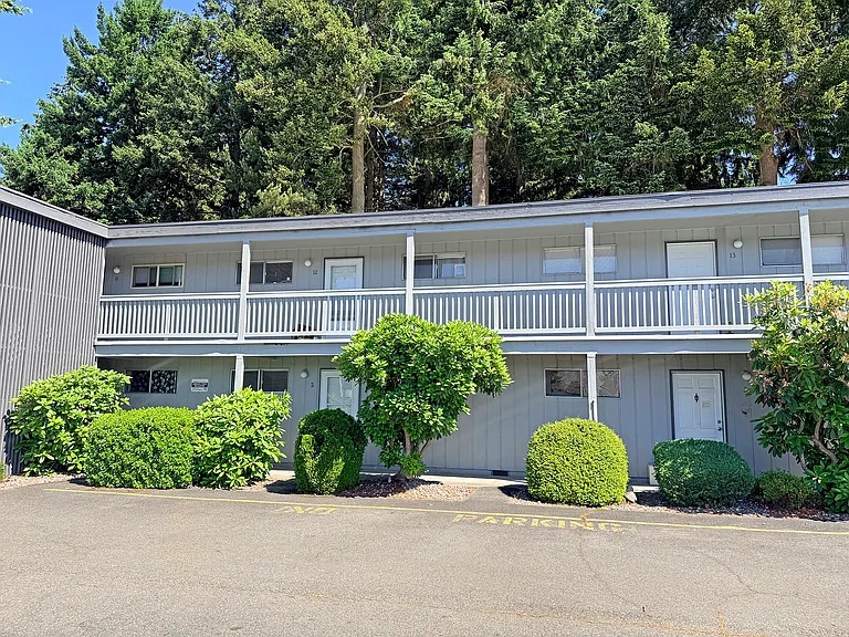 The building against the backdrop of evergreens.