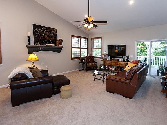 Great room features vaulted ceiling, ceiling fan, recessed lighting and plantation shutters. Sliding glass door leads to partial