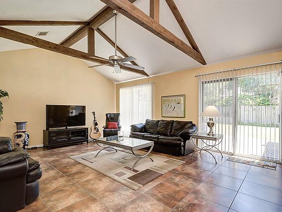 The living room has nice high ceilings with wood beams, tile floors and plenty of sunlight!