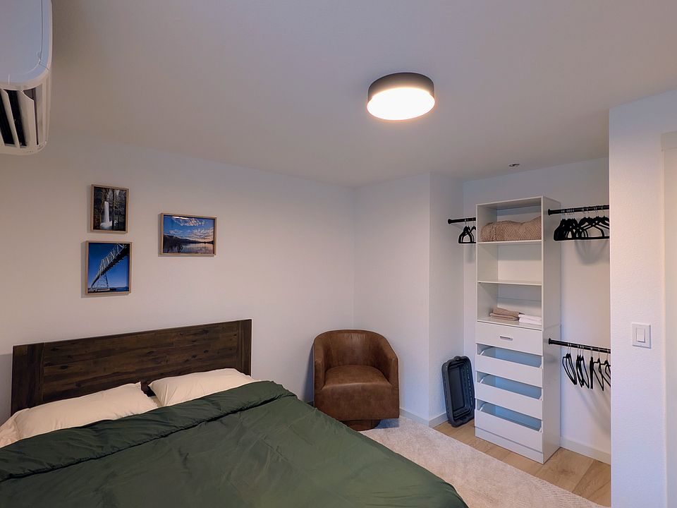 Queen size bed, closet system, and a lounge chair.