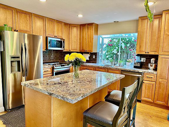 Remodeled kitchen with granite counter top and island and stainless steel applicances