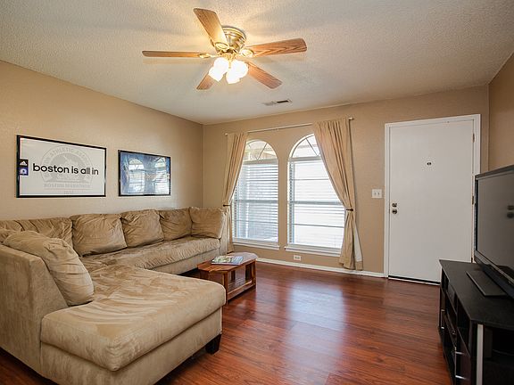 Inviting Family Room with updated flooring, arched windows with updated privacy blinds, ceiling fan and updated neutral paint pallet.  