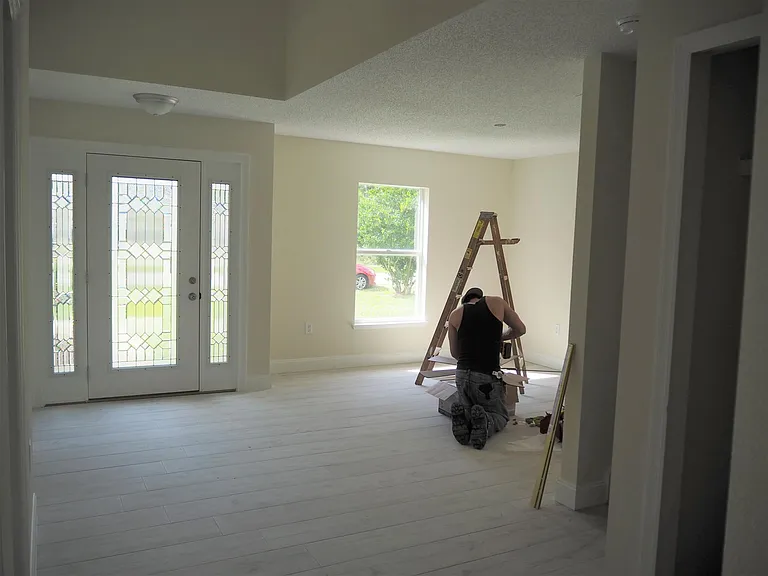 Dining room with ceiling fan being installed.