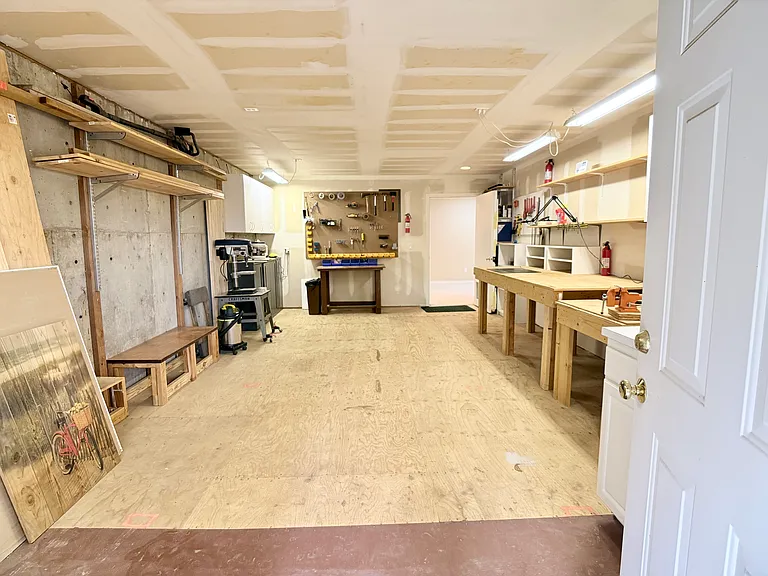 Well-equipped workshop space featuring ample work surfaces, organized tool storage, and direct access to both the home and outdoor amenities.